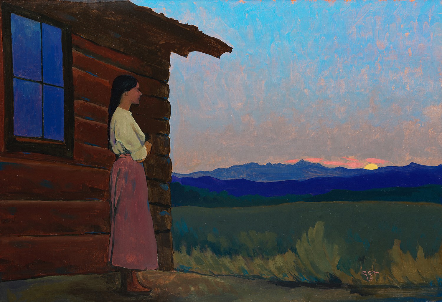 Woman standing outside a wooden house, looking at a sunset over distant mountains and fields.