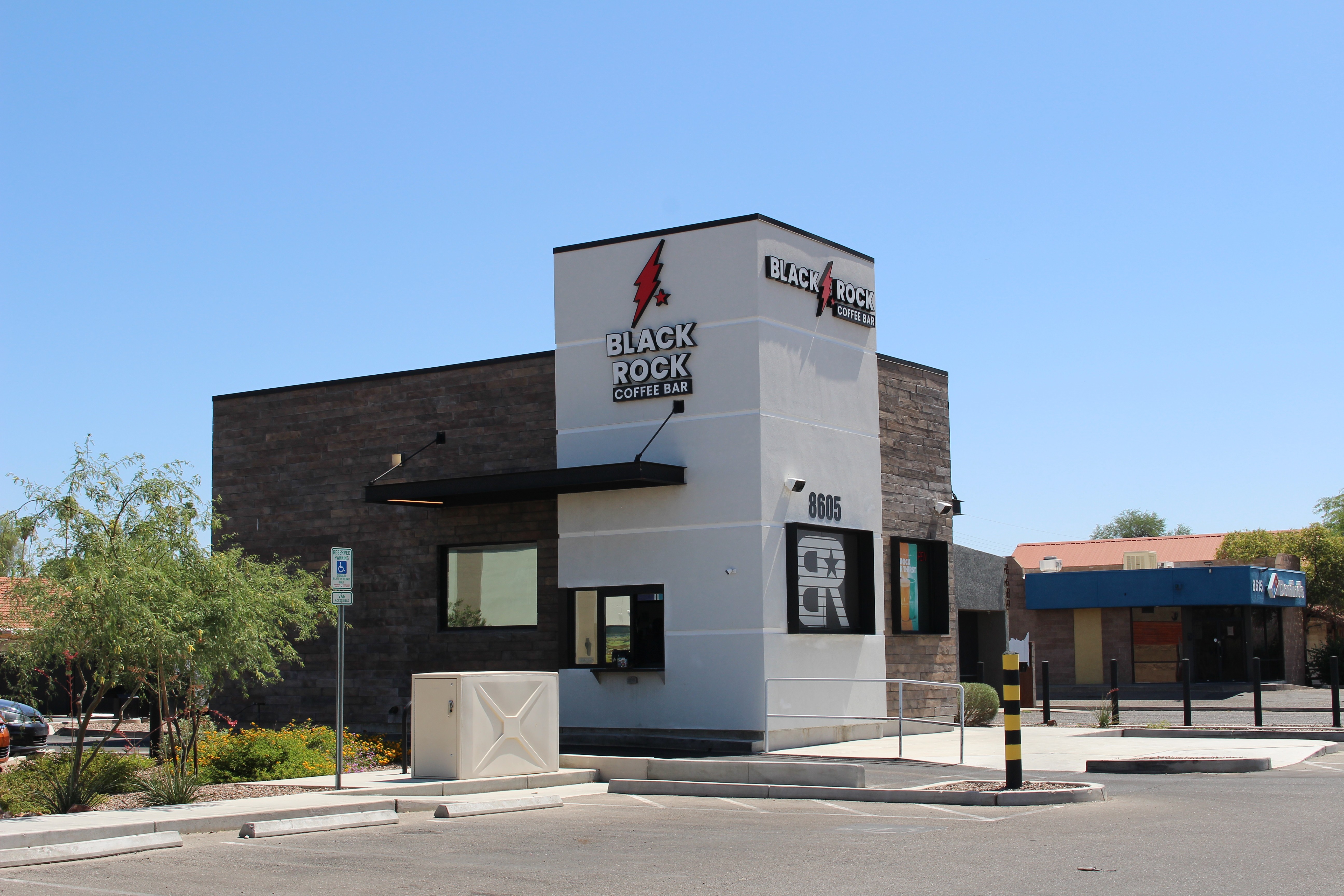 Building with a sign reading 'Black Rock' and a lightning bolt logo, under a clear blue sky.