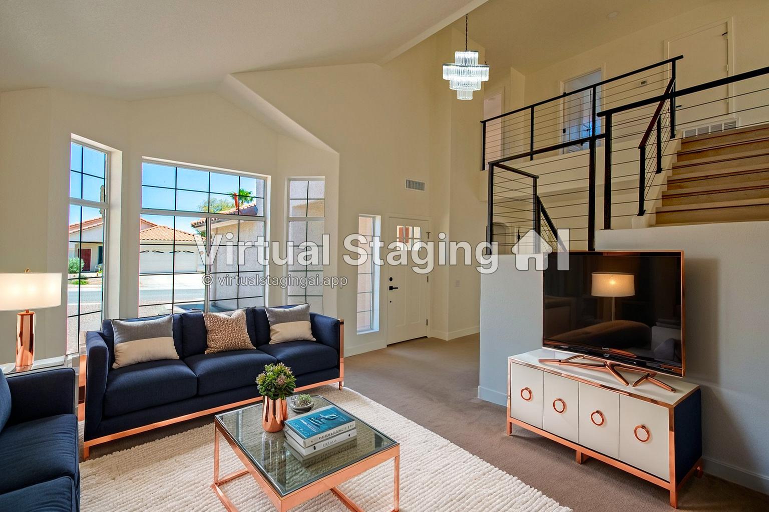 Living room with large windows, navy sofa, coffee table, TV on a stand, staircase, and modern lighting.