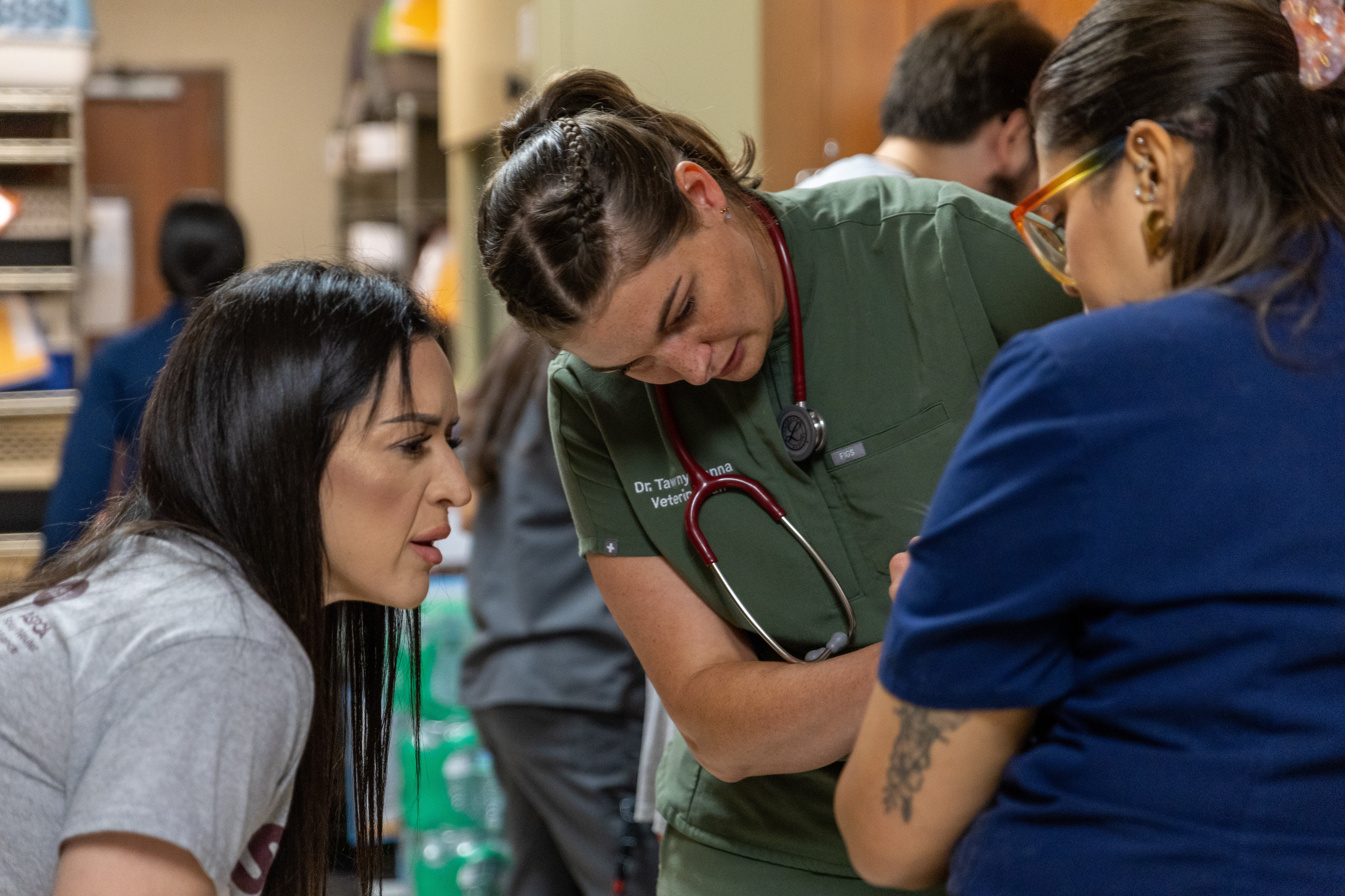 Medical professionals and a patient engaged in a discussion in a clinical setting.