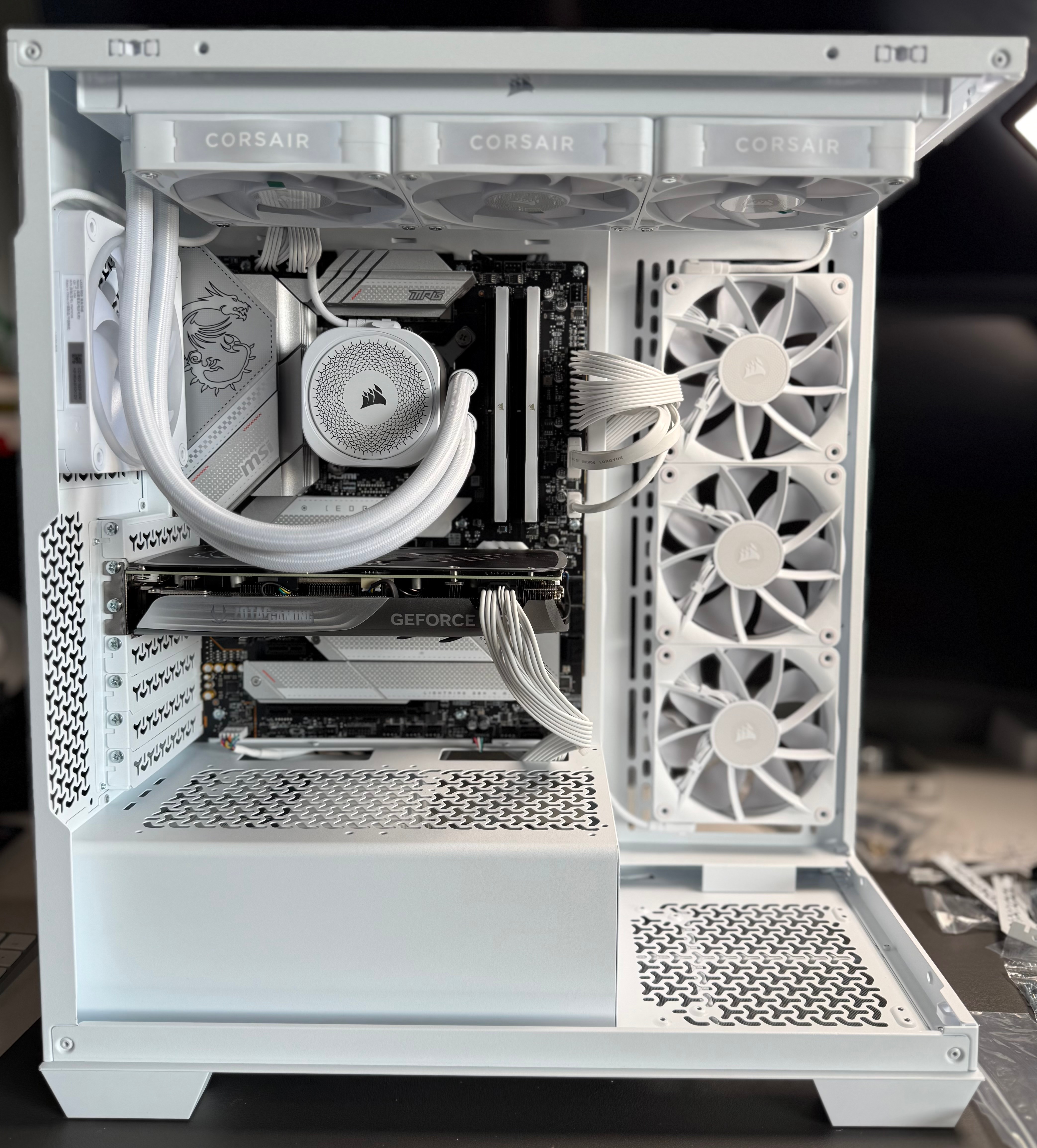 Interior of a white custom-built gaming PC with cooling fans, RAM, GPU, and liquid cooling system visible.
