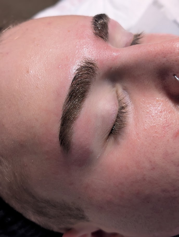 Close-up of a person's face with closed eyes, showing eyebrows and skin texture, rotated 90 degrees clockwise.